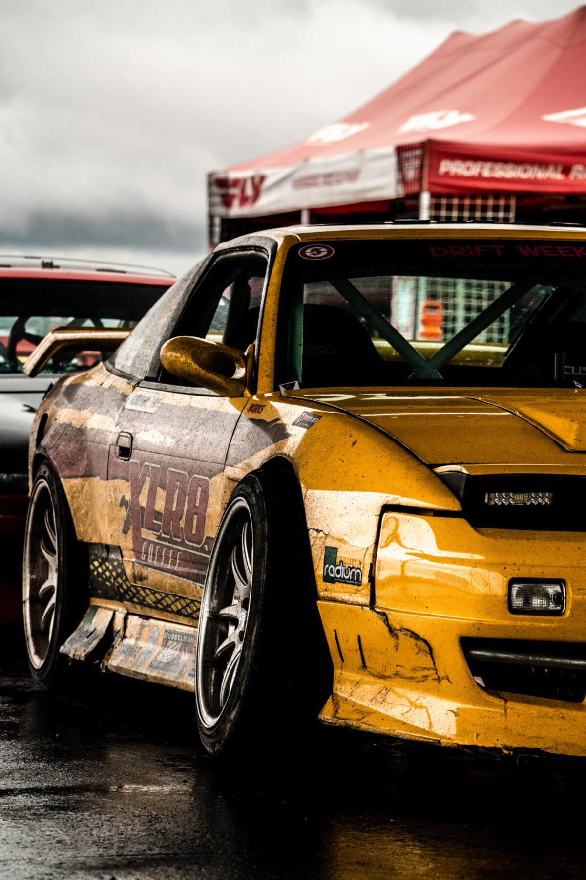 The battle-scarred XLR8 Nissan S13 in the paddock